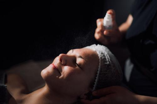 a woman getting a bath with a bottle of soap at OTTO Hotel & Sun in Pāvilosta