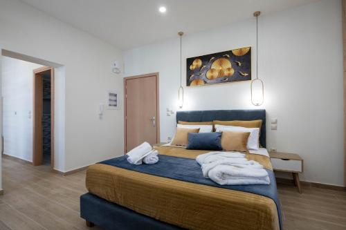 a bedroom with a large bed with towels on it at Kalypso Apartments in Kalamata