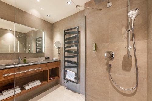 a bathroom with a shower and a sink at Hotel Pramstraller in Mayrhofen