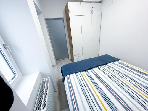 um pequeno quarto com uma cama e uma janela em APARTMA GALEB em Piran