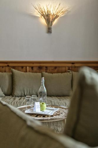 a table with a bottle and glasses on a couch at Alpin Juwel - Bio und Lifestylehotel in Saalbach Hinterglemm