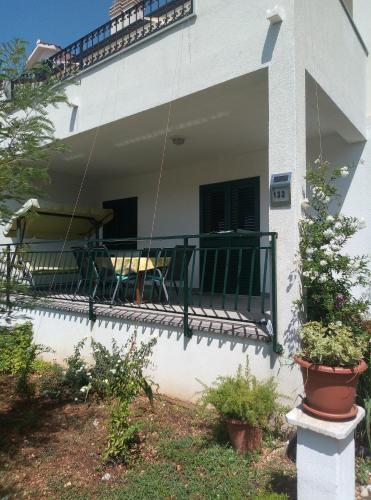 a house with a balcony with a table and chairs at Lux Trogir in Trogir