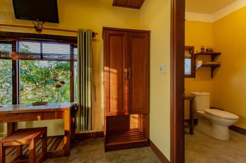 ein Bad mit einem WC, einem Schreibtisch und einem Fenster in der Unterkunft Chez Xuan - Private Villa Hoian in Hoi An