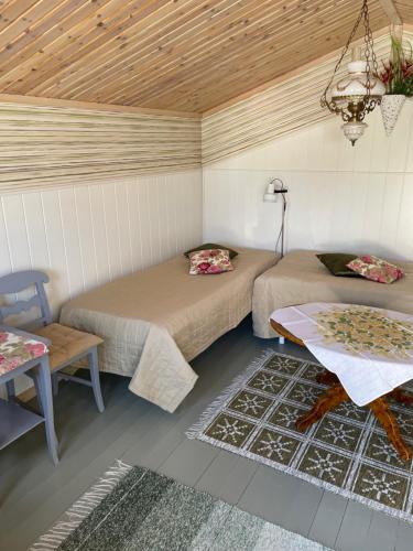 a room with two beds and a table in it at Mysigt och centralt in Strömstad