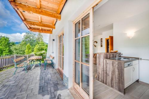 a kitchen with a deck with a table and chairs at Chaletdorf am Sonnenhang in Neukirchen am Großvenediger