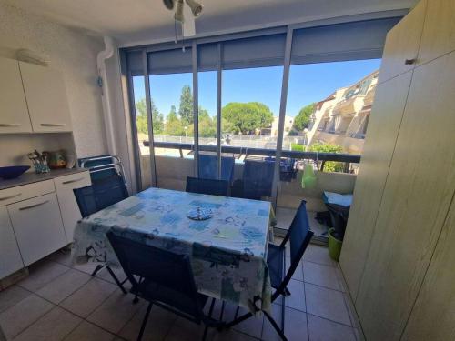 - une table et des chaises dans la cuisine avec vue dans l'établissement Studio cabine avec piscine et parking à Marseillan - FR-1-326-607, à Marseillan
