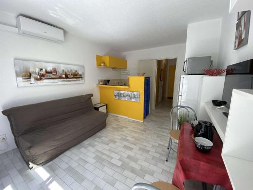 un salon avec un canapé et une cuisine dans l'établissement Studio cabine climatisé avec parking à Port Camargue, proche plage - FR-1-250-208, au Grau-du-Roi