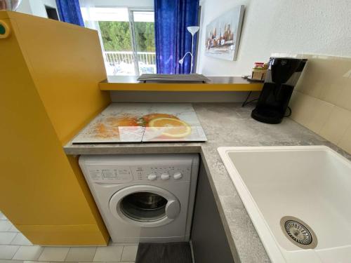 une petite cuisine avec une machine à laver et un évier dans l'établissement Studio cabine climatisé avec parking à Port Camargue, proche plage - FR-1-250-208, au Grau-du-Roi