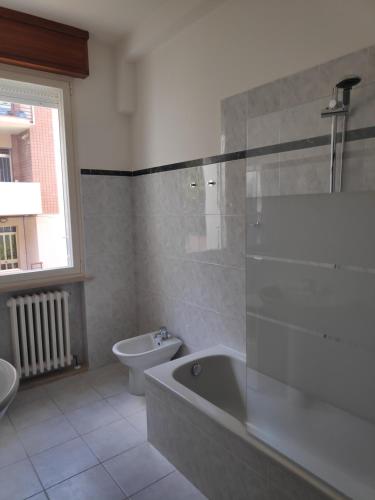 a bathroom with a tub and a toilet and a sink at Appartamento Panoramica in Pesaro