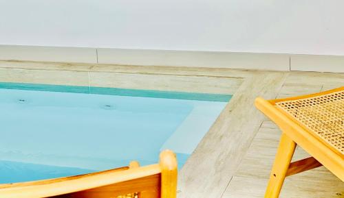 a swimming pool with a table and a chair at Canaryislandshost l Boya Suites in Playa Honda