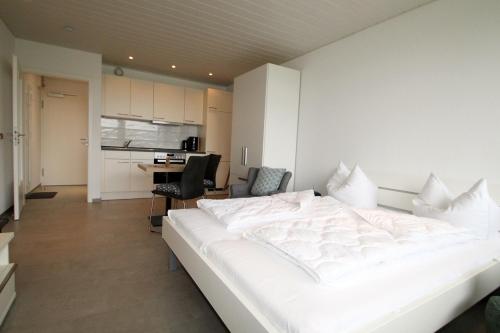 un grande letto bianco in una stanza con cucina di Steinwarder 35-37 SCE 011 Steinwarder 35-37 a Heiligenhafen