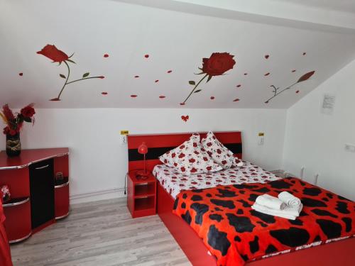 a bedroom with a red bed with flowers on the ceiling at Pensiunea Constanta in Bran