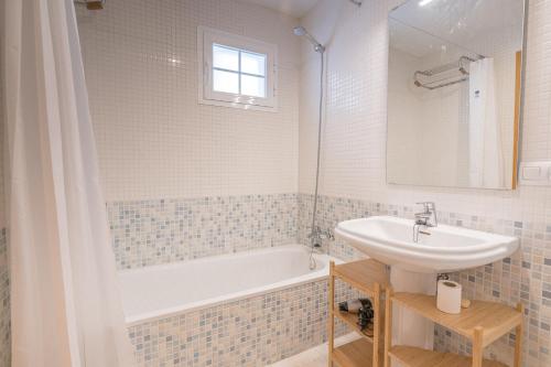 Un baño blanco con lavabo y bañera. en Blue Marine Gardens I with Pool, en La Herradura