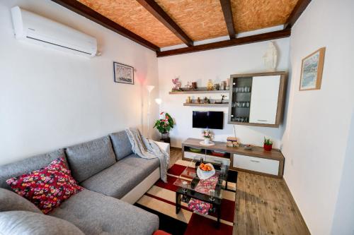 a living room with a couch and a table at Country house Oasis with private tennis court in Sveti Filip i Jakov