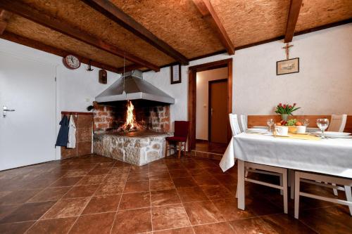 a dining room with a fireplace and a table with a tablecloth at Country house Oasis with private tennis court in Sveti Filip i Jakov