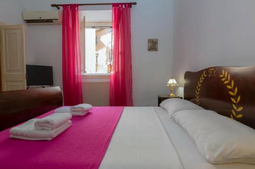 ein Schlafzimmer mit einem großen Bett mit zwei Handtüchern darauf in der Unterkunft Campiello Apartments in Korfu-Stadt