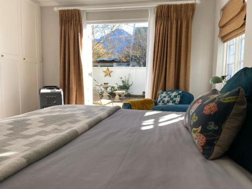 um quarto com uma cama grande e uma janela grande em Courtyard on Weder em Greyton