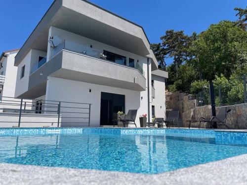 uma villa com piscina em frente a uma casa em Vila - Mimi em Dramalj