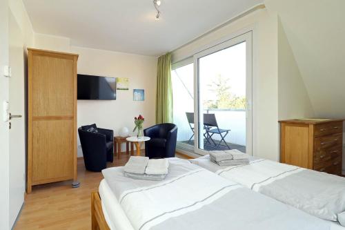sypialnia z łóżkiem i dużym oknem w obiekcie Ferienhaus DHH Ostlandstraße 7 w mieście Sankt Peter-Ording