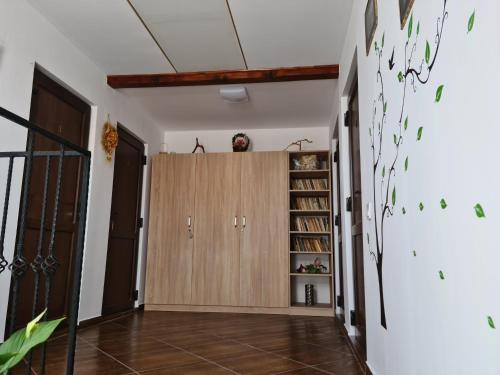 a hallway with wooden cabinets and a book shelf at Pensiunea Constanta in Bran
