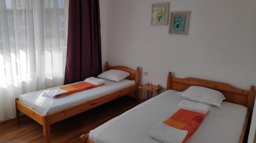 two twin beds in a room with a window at Къща за гости Снежа/ Guest house Snezha in Obzor