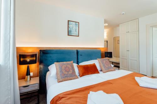 a bedroom with a large bed with orange pillows at Hotel Glaus in Banská Štiavnica