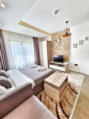 a bedroom with a large bed and a couch at Milmari S70 Kopaonik in Kopaonik