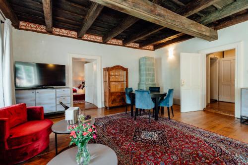 a living room with a red couch and a table at Hotel Glaus in Banská Štiavnica