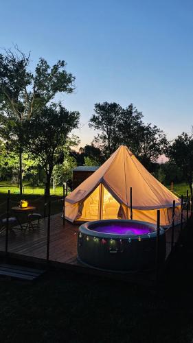 a tent in a field with a table and a table at Green Garden Glamping Retezat in Bălan