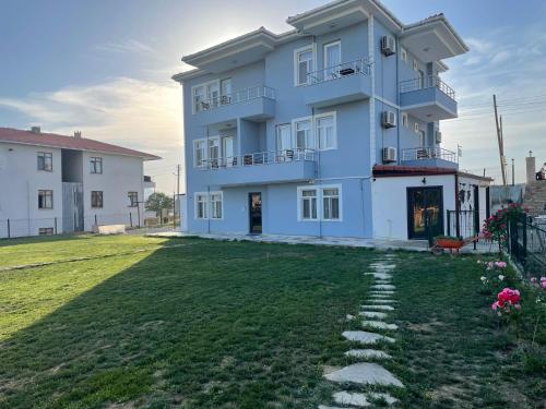 a large house with a grass yard in front of it at Parli Hotel in Gokceada Town