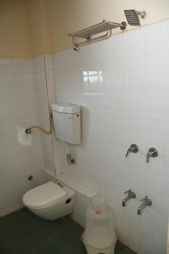 a bathroom with a toilet and a sink at Hotel Nawanagar Residency in Jamnagar