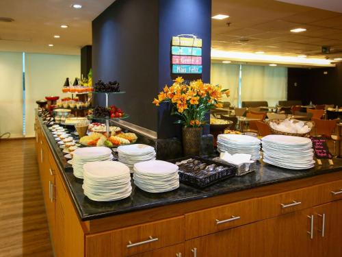 a kitchen counter filled with lots of different types of food at ibis Rio de Janeiro Santos Dumont in Rio de Janeiro