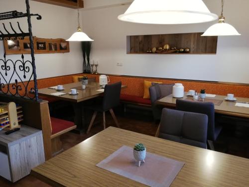 ein Restaurant mit Holztischen, Stühlen und Lampen in der Unterkunft Haus Seppi in Neukirchen am Großvenediger