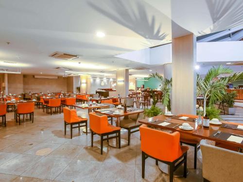 a dining room with tables and chairs and a restaurant at ibis Rio de Janeiro Barra da Tijuca in Rio de Janeiro