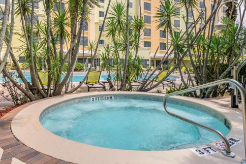 a hot tub with palm trees and a building at Comfort Suites Maingate East in Orlando