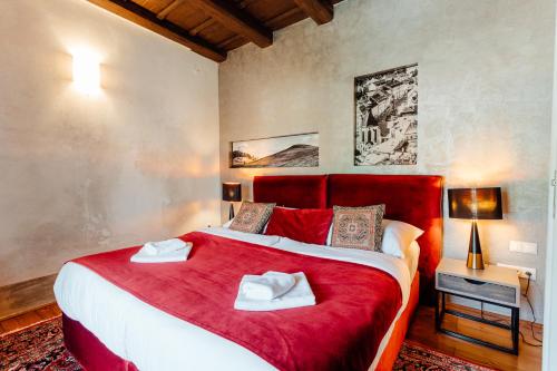 a bedroom with a large bed with red sheets at Hotel Glaus in Banská Štiavnica