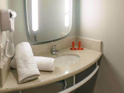 a bathroom with a sink and a mirror at ibis Itatiba in Itatiba