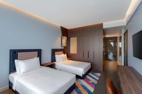 a hotel room with two beds and a table at Hyatt Centric Jumeirah Dubai in Dubai