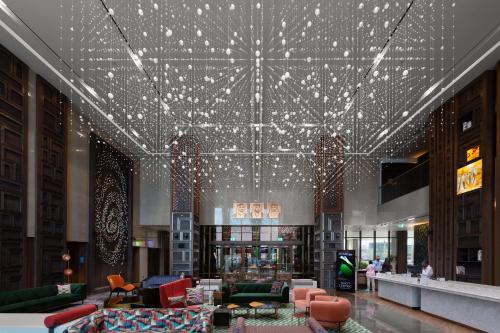 a lobby with a lot of lights on the ceiling at Hyatt Centric Jumeirah Dubai in Dubai