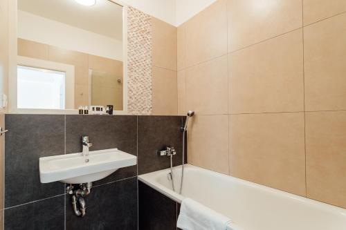 a bathroom with a sink and a bath tub at Hotel Glaus in Banská Štiavnica