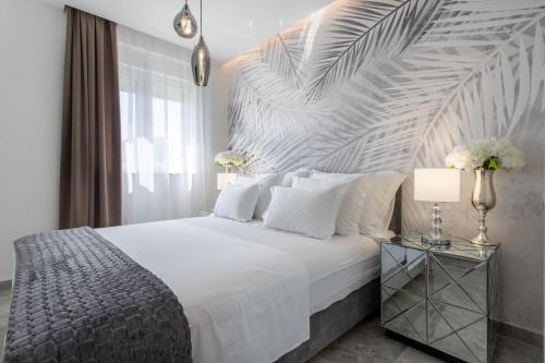 a bedroom with a large white bed with a wooden headboard at Apartments Taratta 1 in Trogir