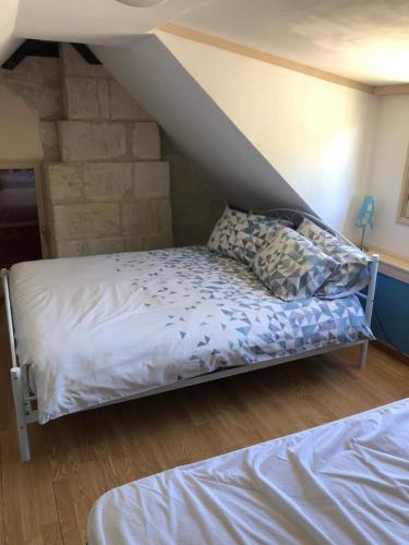 Bett in einem Zimmer mit einer Steinmauer in der Unterkunft Cottage La Halouère in Saint-Philbert-du-Peuple