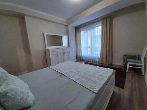 a bedroom with a large bed and a window at Ecohouse in Bishkek
