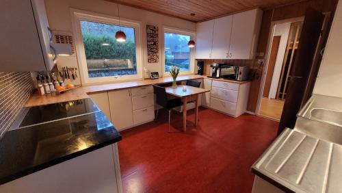 a kitchen with white cabinets and a red floor at Villa with great view in Sandnes