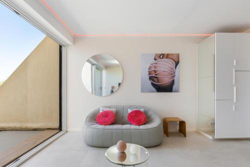 un salon avec un canapé et un miroir dans l'établissement Village naturiste R4N - Le Love Nest Heliopolis Luxe, au Cap d'Agde