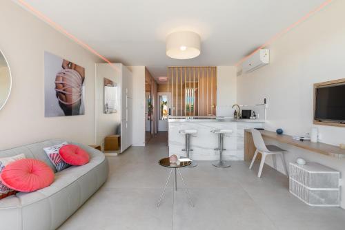 un salon avec un canapé et une cuisine dans l'établissement Village naturiste R4N - Le Love Nest Heliopolis Luxe, au Cap d'Agde