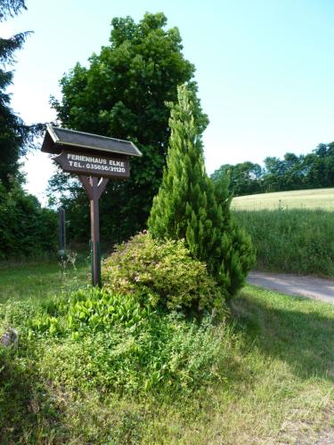 a street sign in the grass next to a road at Ferienhaus Elke in Kurort Altenberg