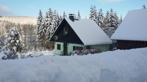 a small house with snow on the roof at Ferienhaus Elke in Kurort Altenberg