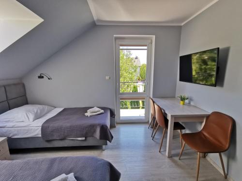 a bedroom with a bed and a desk and a table at Przedsiębiorstwo Turystyczne "SOL" in Grzybowo