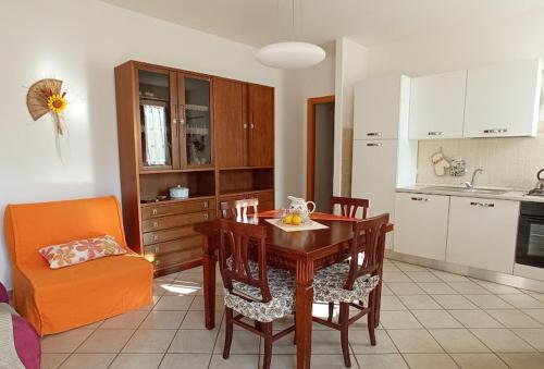una cucina e una sala da pranzo con tavolo e sedie di Appartamento Il Glicine a Montalcino